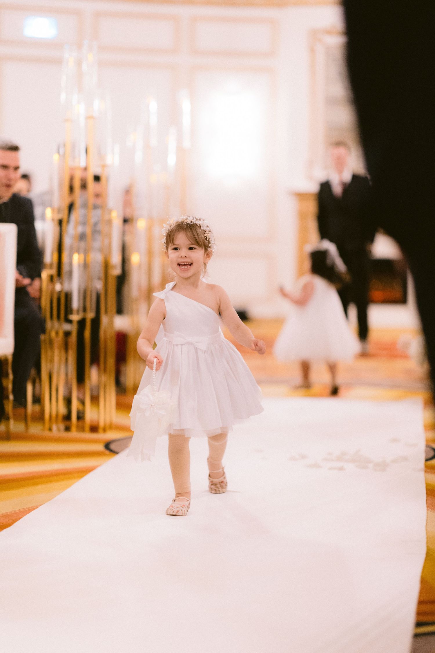 A series of connected photos showing a child in white formal attire walking across a light-colored floor.