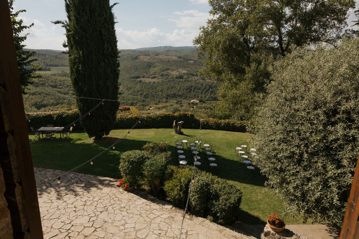 Panoramic view of rolling Tuscan hills with cypress trees and olive groves.