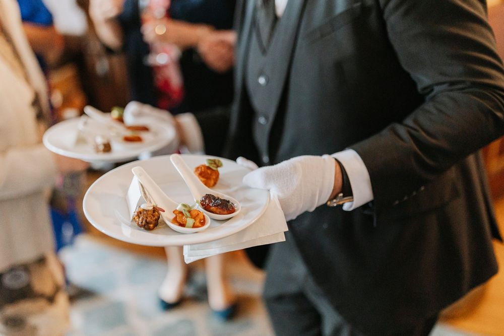 Wedding guests enjoy appetizers and drinks during an elegant indoor reception celebration.
