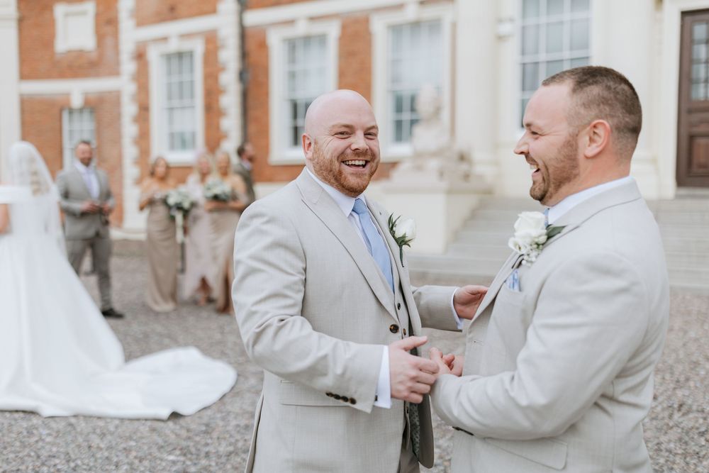 Two people in light colored formal attire share a joyful moment together during a wedding celebration.