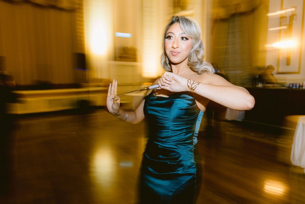 Motion-blurred dance sequence showing a couple twirling across an elegant ballroom floor in evening attire.