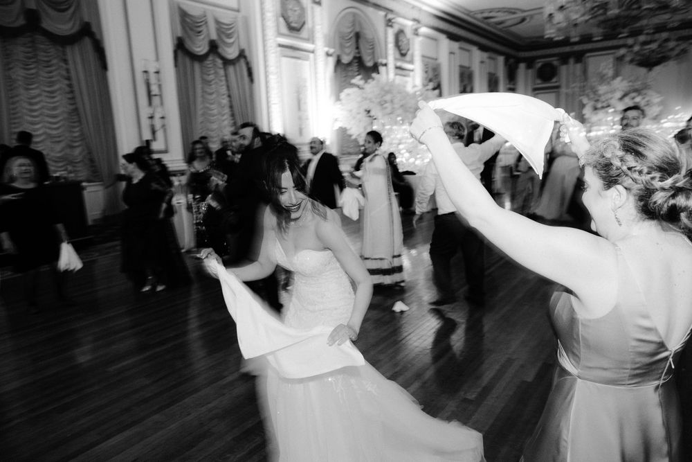A couple dances together during their first dance at a wedding reception in a grand ballroom.