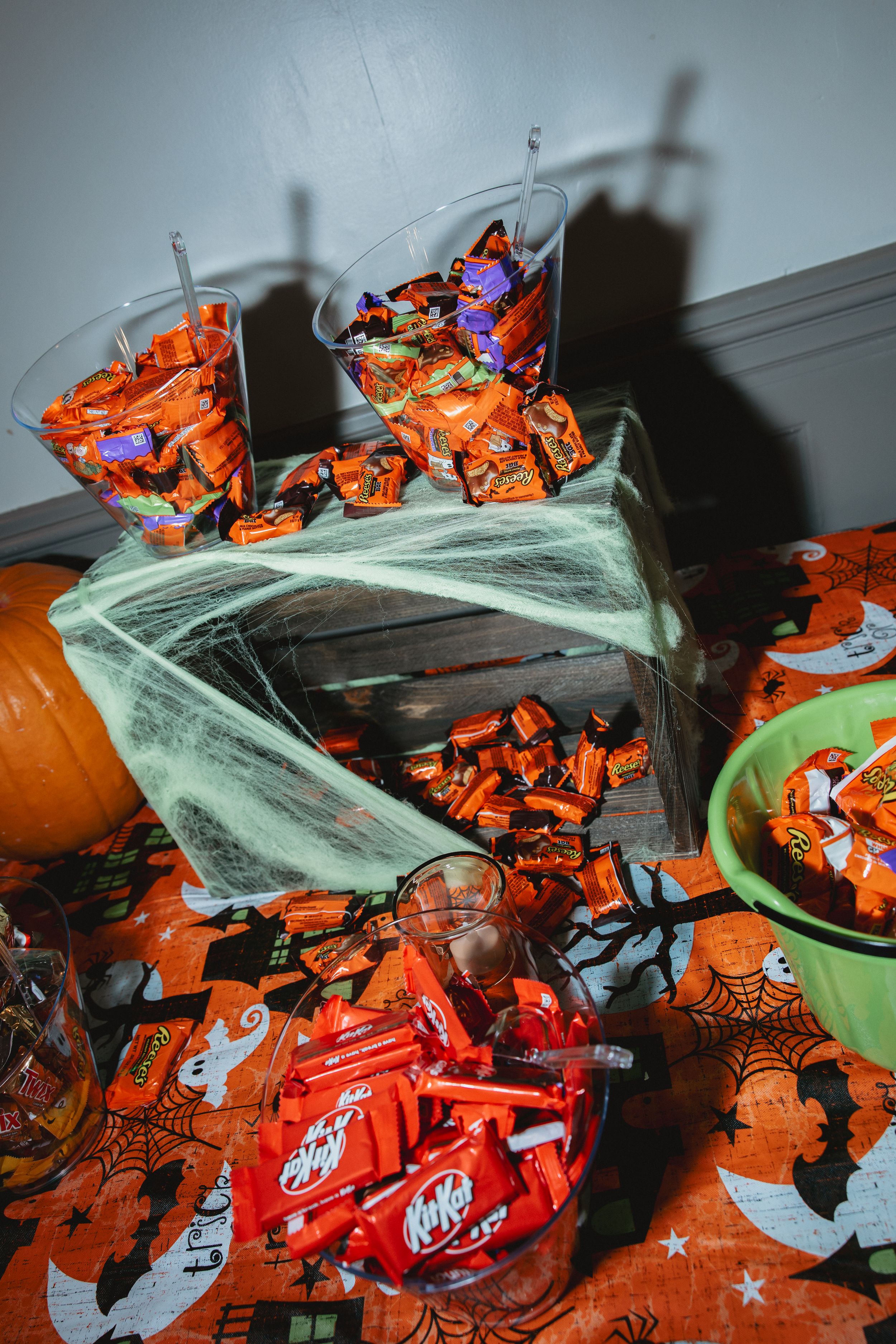 A spooky Halloween scene with orange candy wrappers and decorative cobwebs creating an eerie atmosphere.