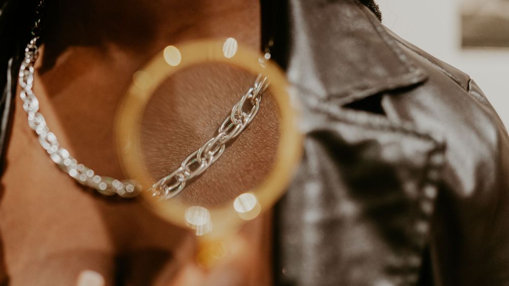 Close-up shot of silver chain bracelets with bokeh light effects.