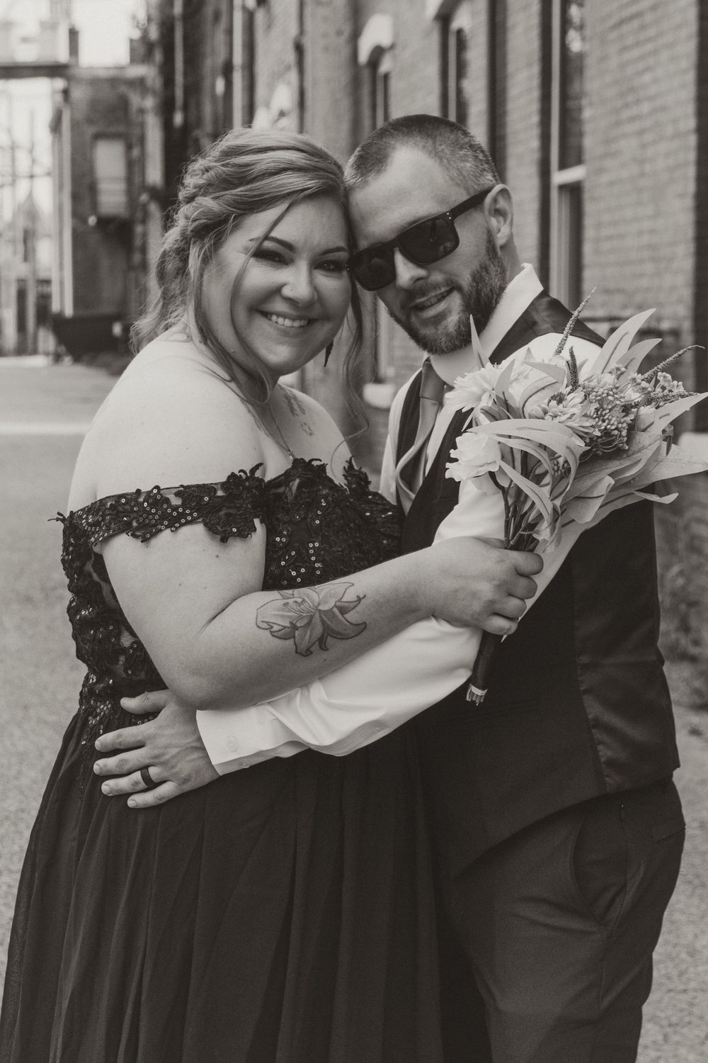 Romantic black and white wedding photo series showing couple embracing in an urban setting.