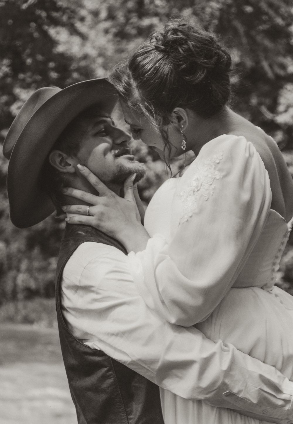 A series of black and white romantic photographs showing a couple embracing and kissing while wearing vintage clothing outdoors.