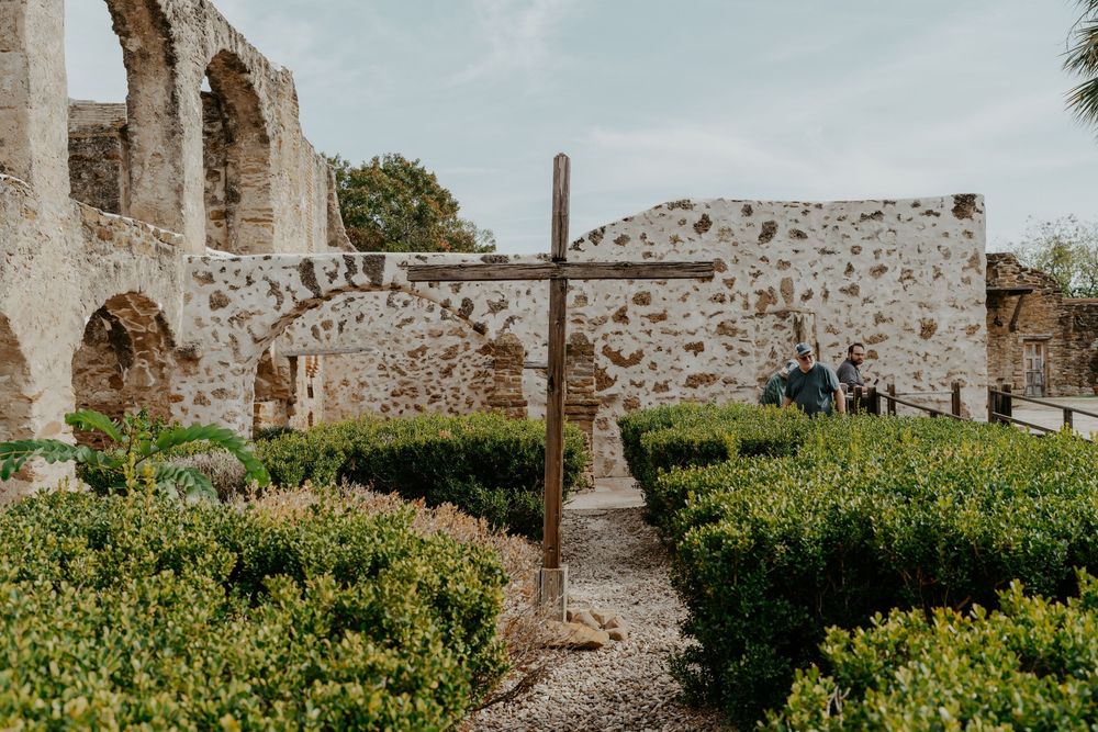 Ancient stone ruins and walls stretch across a historic mission grounds.