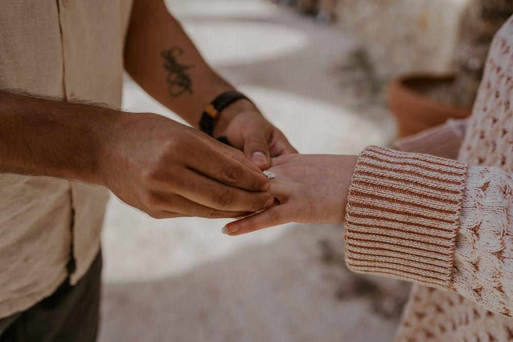 Close-up of hands reaching toward each other in an intimate moment.