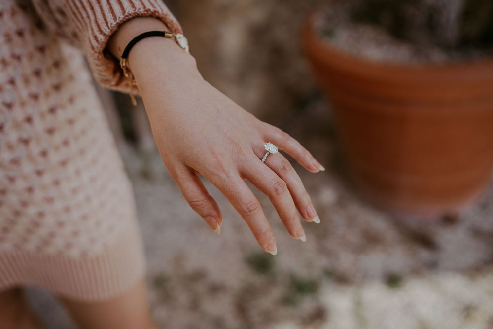 Hands gently touching in a romantic gesture against textured clothing.