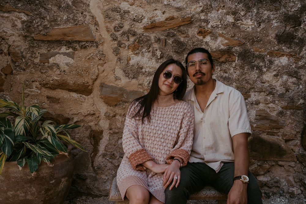 A romantic couple moment captured against weathered stone walls.