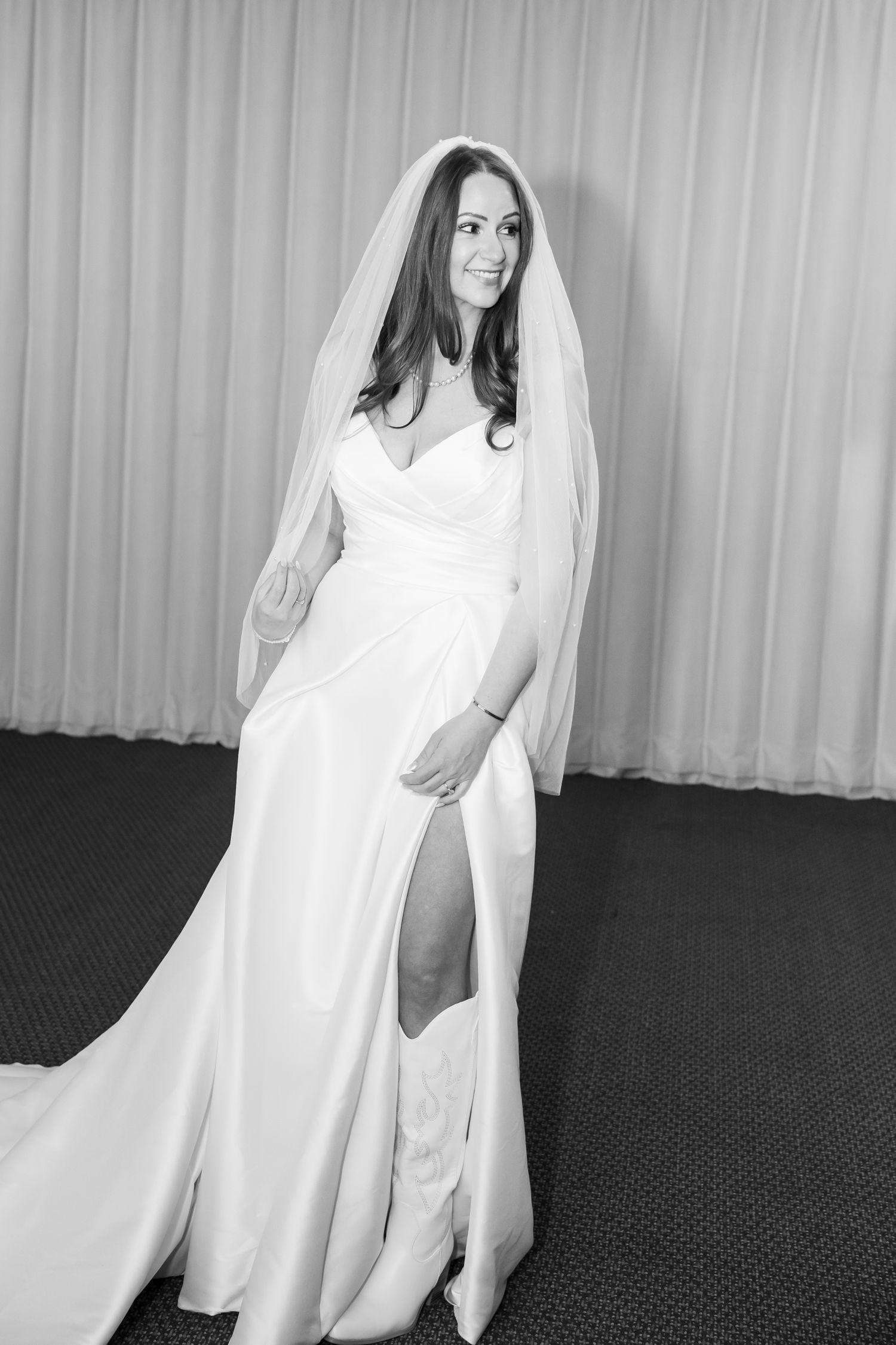 Bridal portrait in black and white showing off her white cowboy boots before her wedding ceremony at The Beaver Creek Chapel.