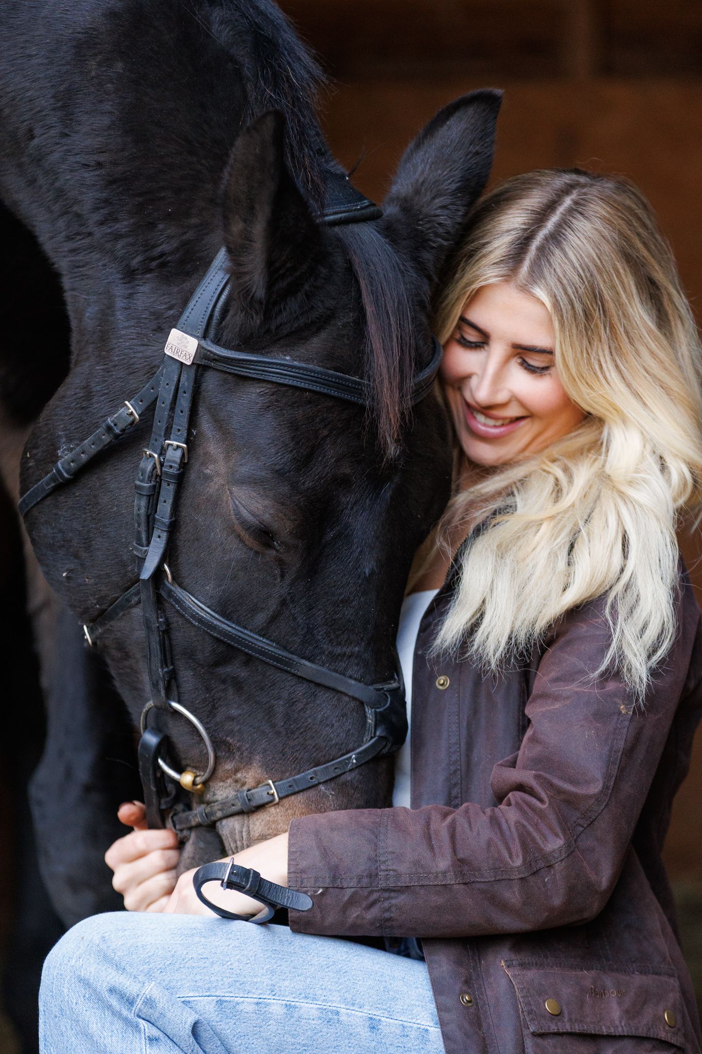 A woman in a brown leather jacket shares tender moments with a black horse in a series of intimate portraits.