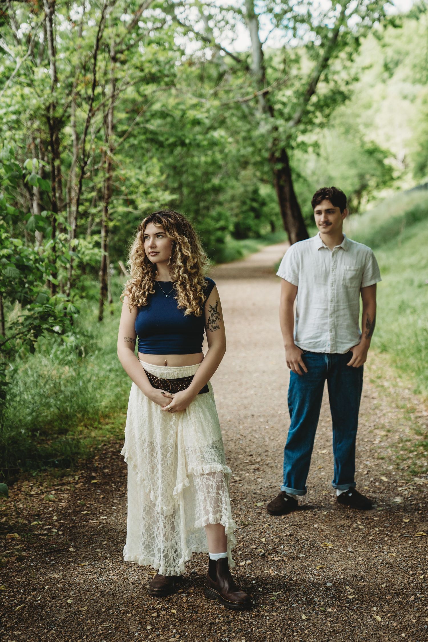 Couple walking together on a wooded path during autumn.