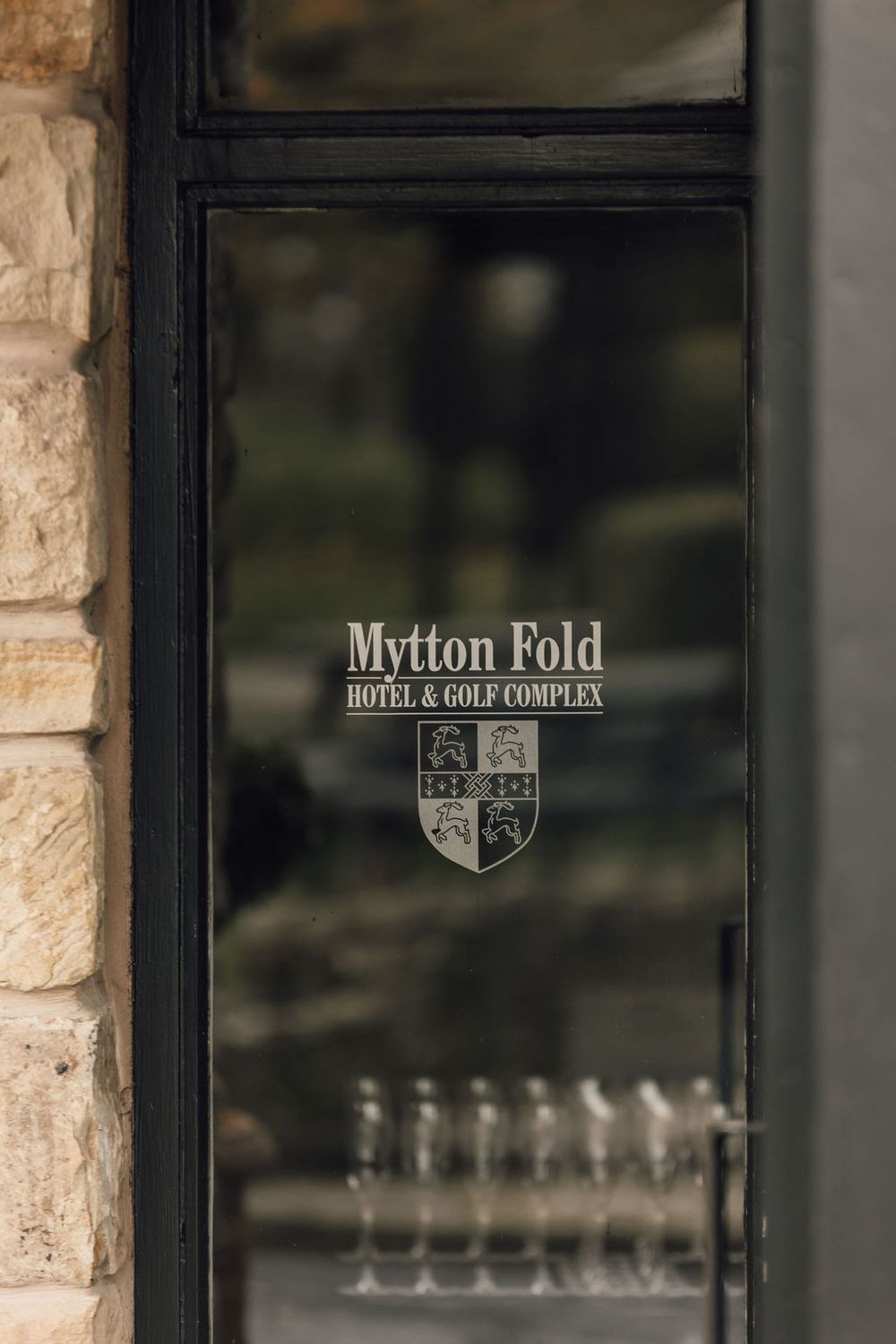 Glass entrance doors displaying the Mytton Fold Hotel & Golf Complex logo and branding.