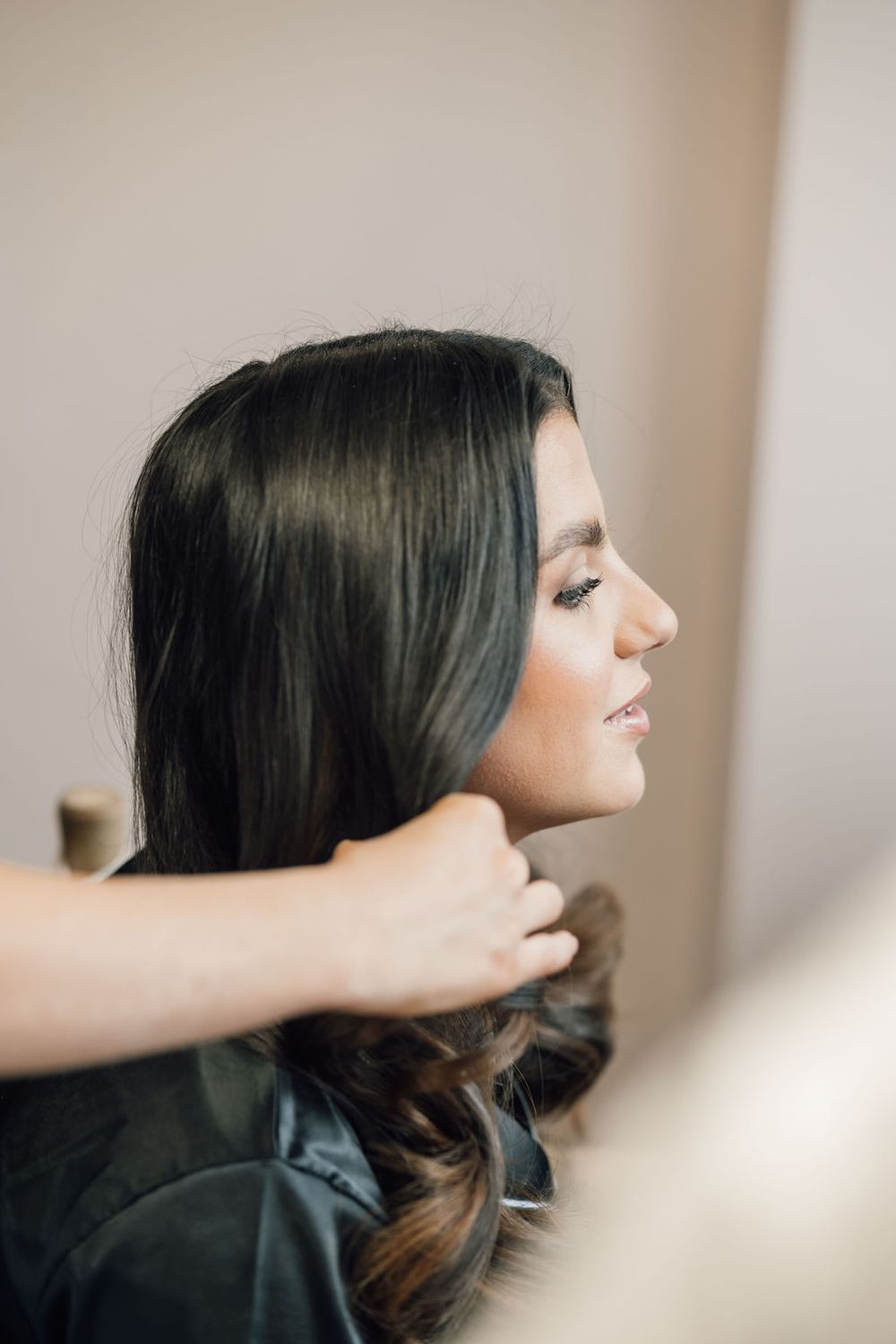 Side profile view of bridal hair and makeup preparation.