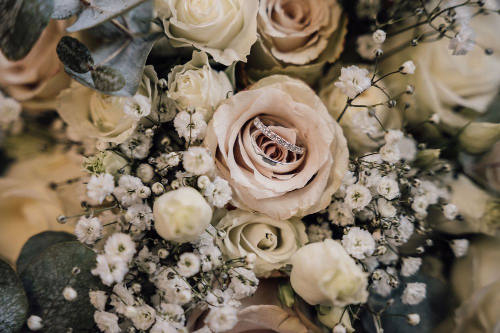Delicate blush roses and baby's breath create romantic wedding floral arrangement.
