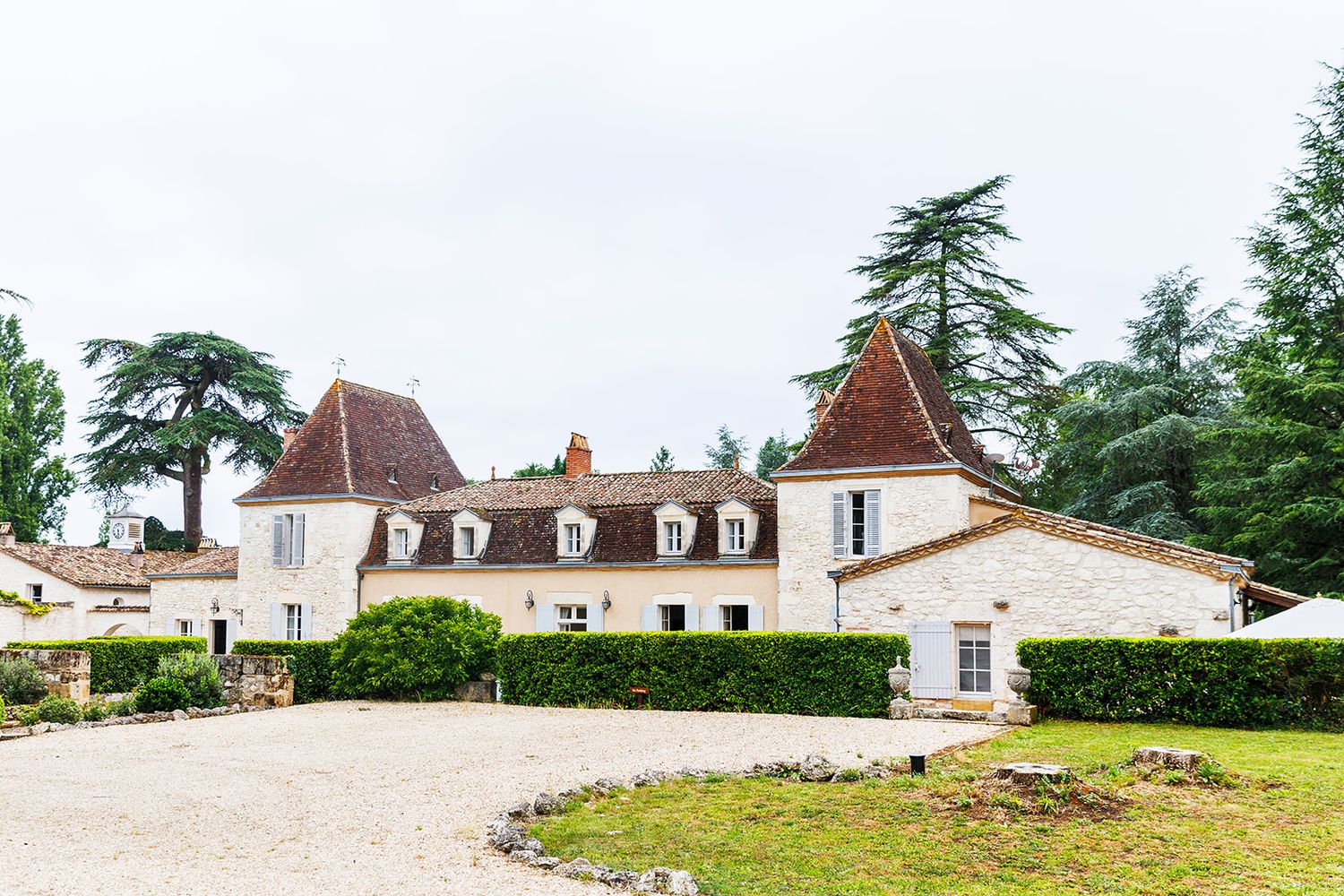 A panoramic view of a French countryside estate with white buildings and manicured gardens.