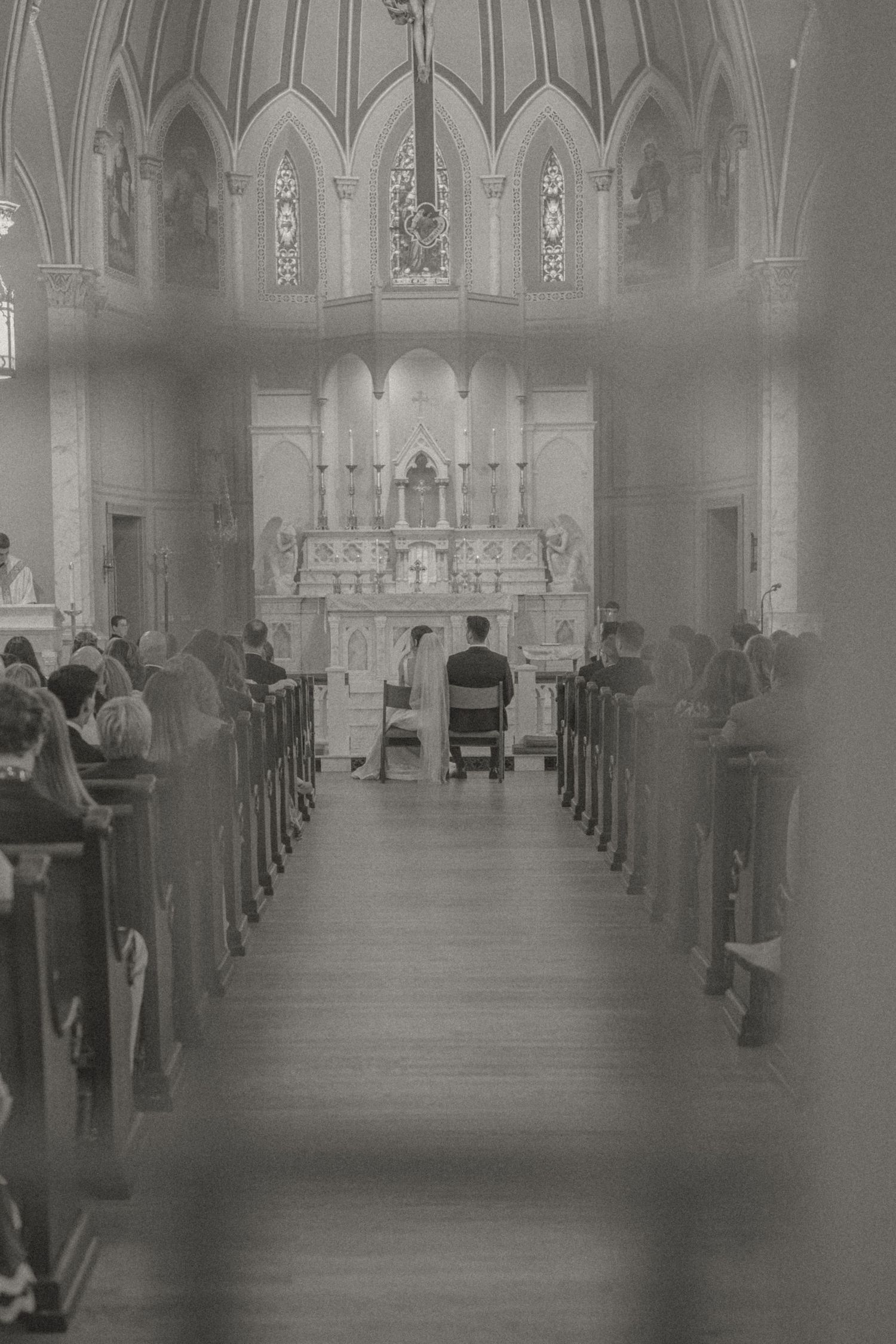 Bride and groom exchanging vows and first kiss at St. Francis of Assisi Church, Staunton, VA, emotional, documentary-style wedding photo.