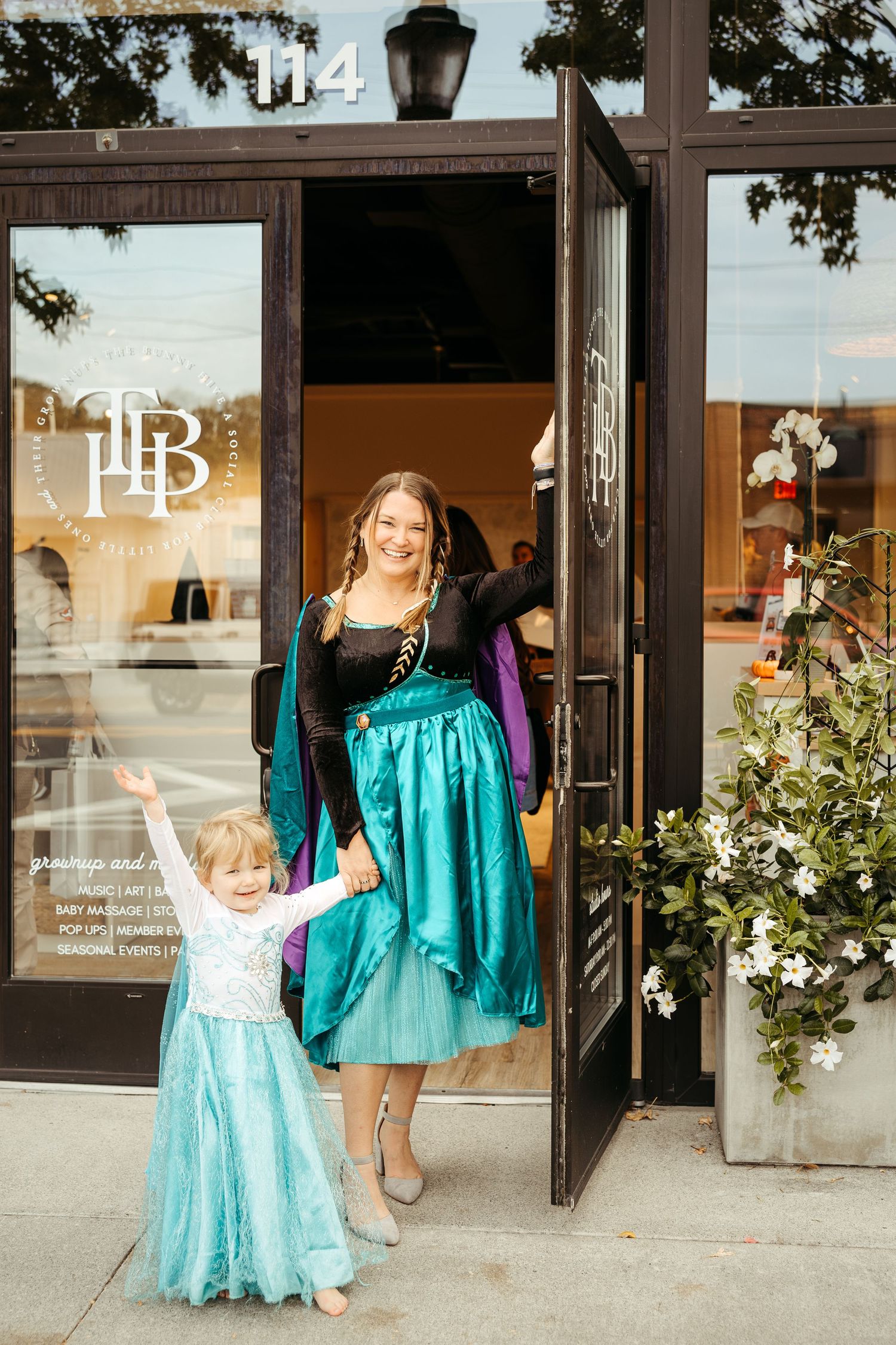 Beth Forrester (The bunny hive chattanooga's owner) & little girl welcoming you in dressed in Frozen Elsa & Ana halloween costumes