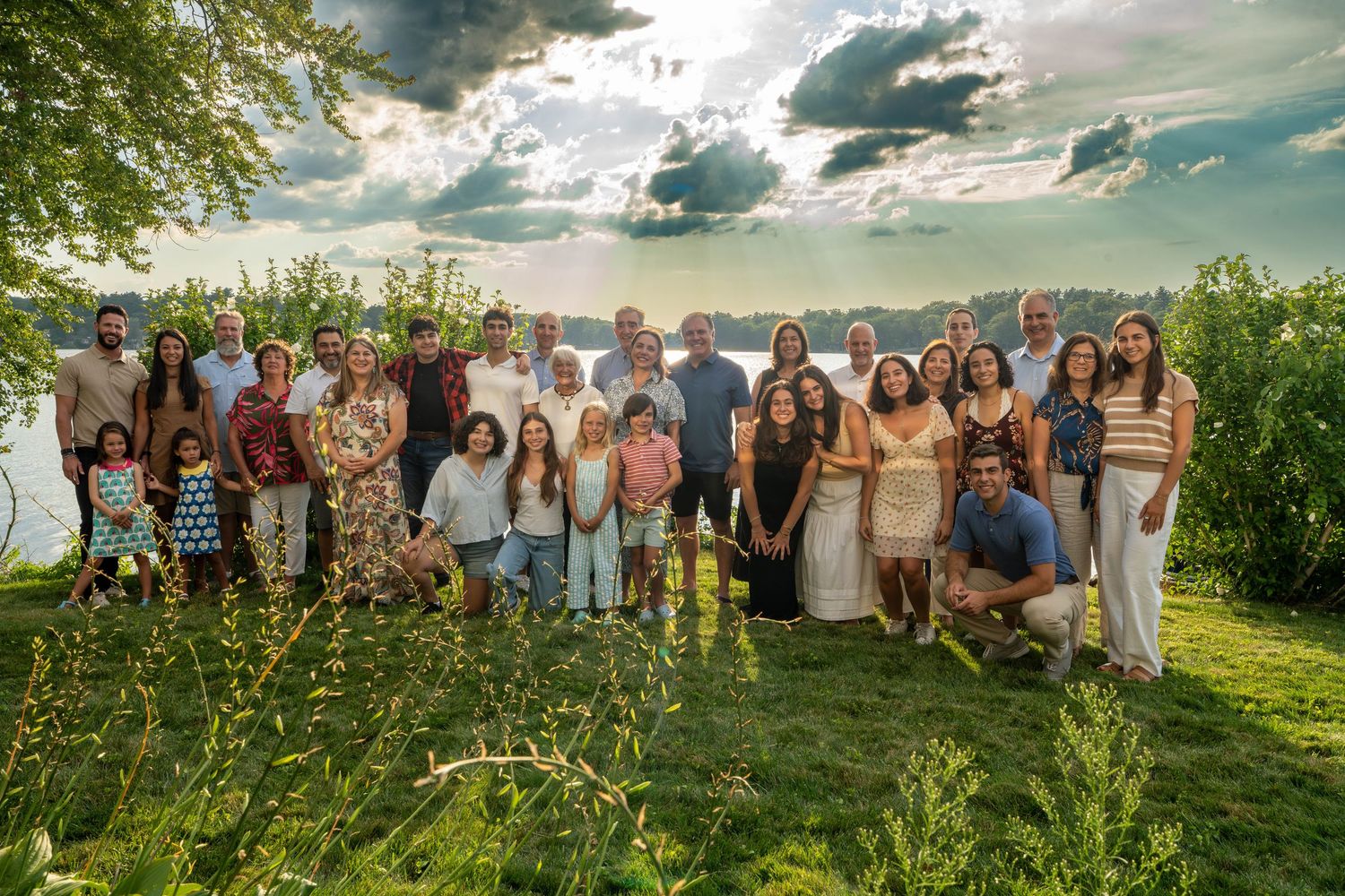 Large group photo of wedding guests gathered outdoors in natural setting.