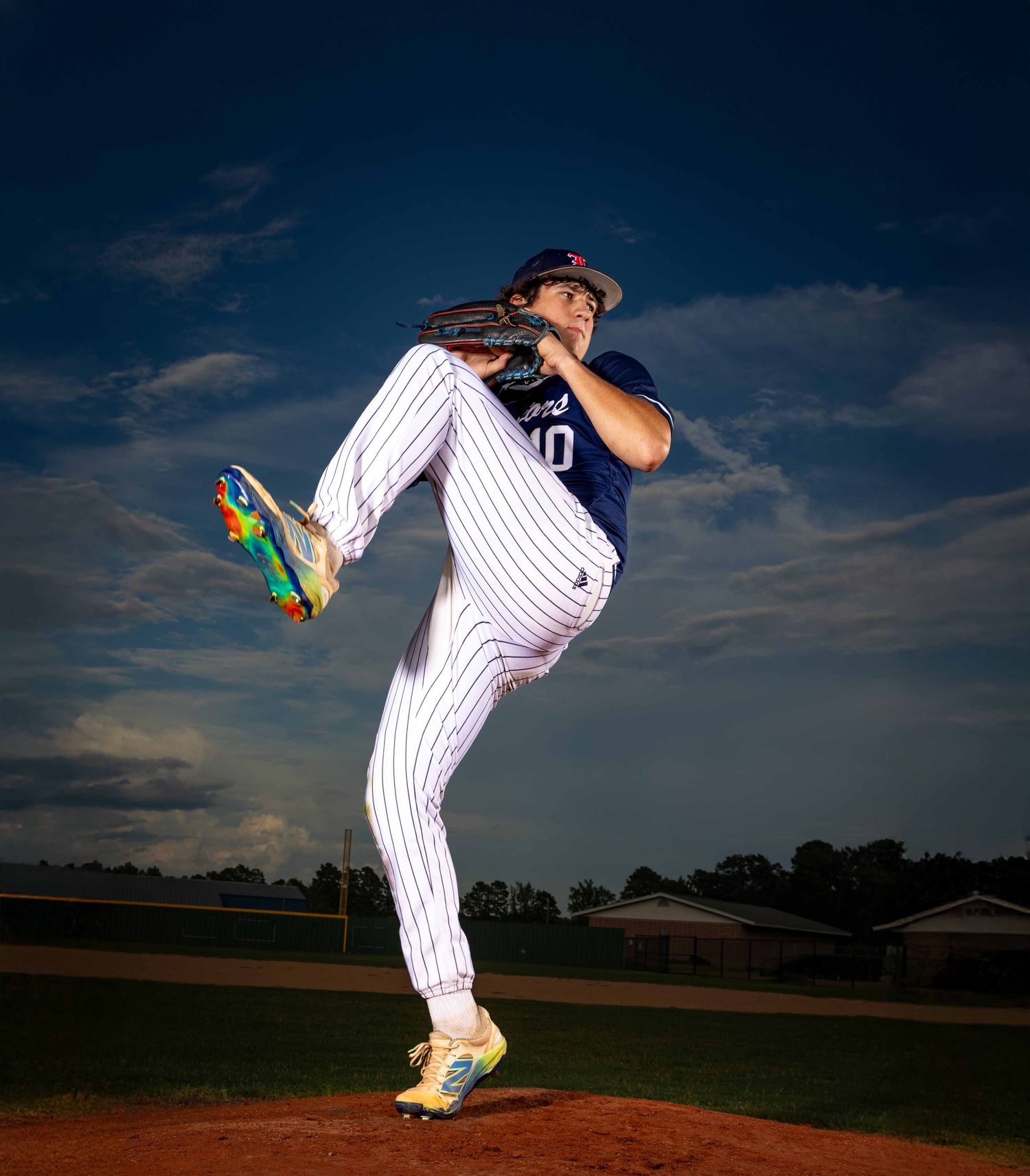 A baseball pitcher shown in multiple action shots throwing a pitch against a dramatic evening sky.