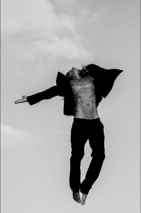 Black and white artistic photo series showing a person falling or floating against a cloudy sky background. Photo session.