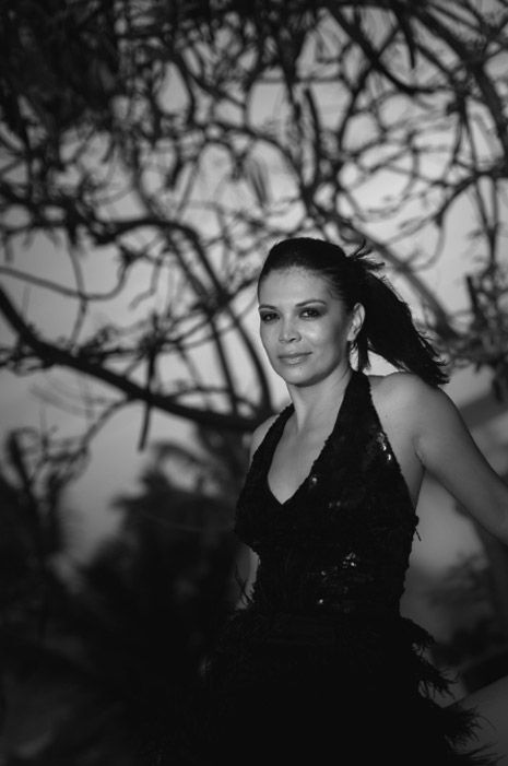 A sequence of black and white portrait photos showing dramatic movement against a dark background with tree branches. Photo session.