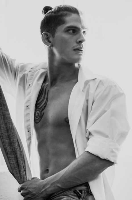 Black and white fashion portrait series showing person in white button-down shirt against neutral background. Photo session.