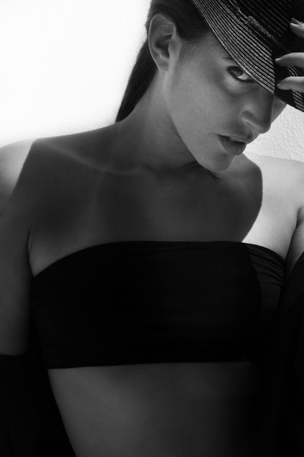 A series of dramatic black and white profile portraits showing someone wearing a dark cap in moody lighting. Punta Cana Lore Larriestra