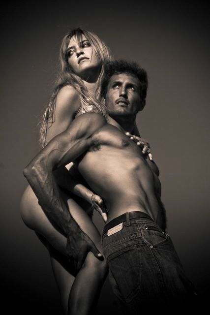 Artistic black and white fashion photo showing two models in dramatic pose against dark background. Punta Cana