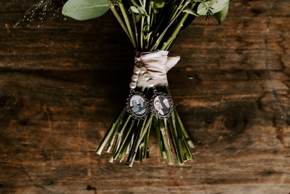 A rustic wooden backdrop displays an elegant white floral bouquet wrapped in twine against dark textured wood.
