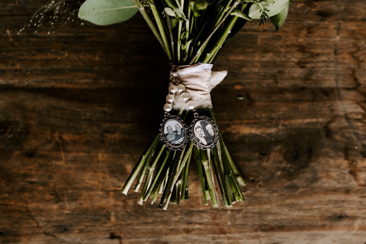 A rustic wooden backdrop displays an elegant white floral bouquet wrapped in twine against dark textured wood.