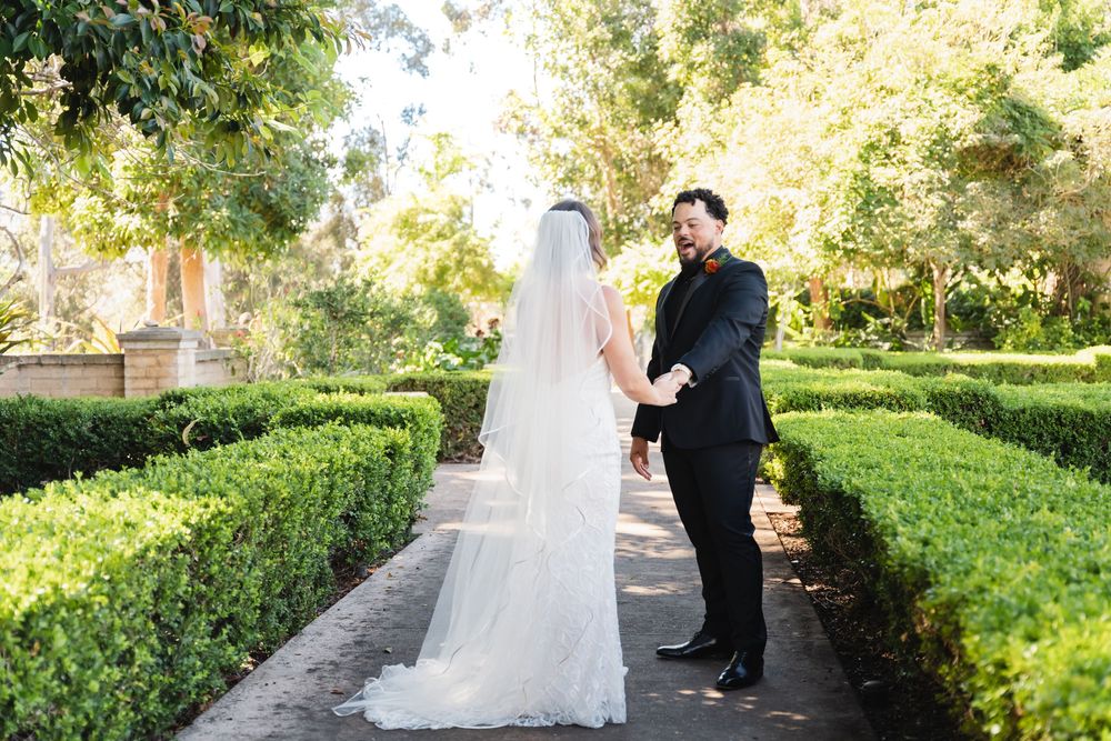 Grooms first look at bride at Alcázar Garden in Balboa Park