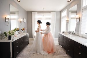 A bright white bridal suite with dark wood cabinets and natural light streaming through large windows.