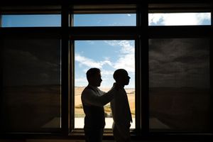 A sequence of silhouettes in window frames against a bright sky creates a cinematic effect.