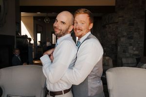 Two people in white dress shirts embrace and share a joyful moment together.