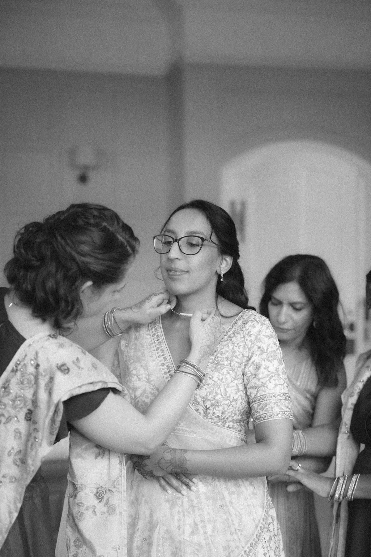 A series of black and white photos showing people in lace dresses dancing together at what appears to be a celebration.