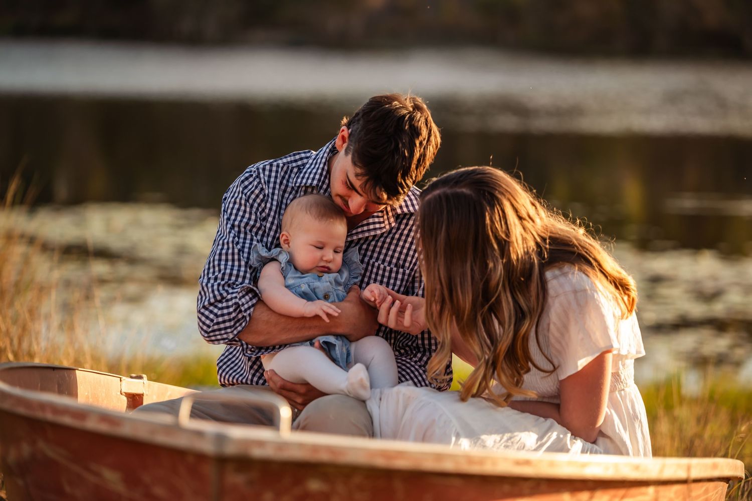 A tender family moment captured at sunset with warm golden light filtering through the trees.
