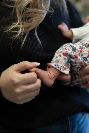 Close-up shots of gentle hands cradling and caressing a tiny newborn.