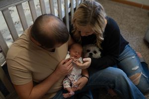 Intimate family photos showing tender moments with a sleeping newborn.