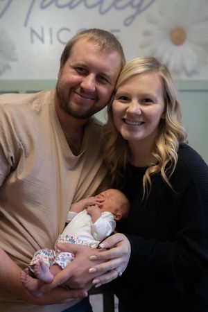 Sweet candid moments of a couple sharing joy with their newborn baby.