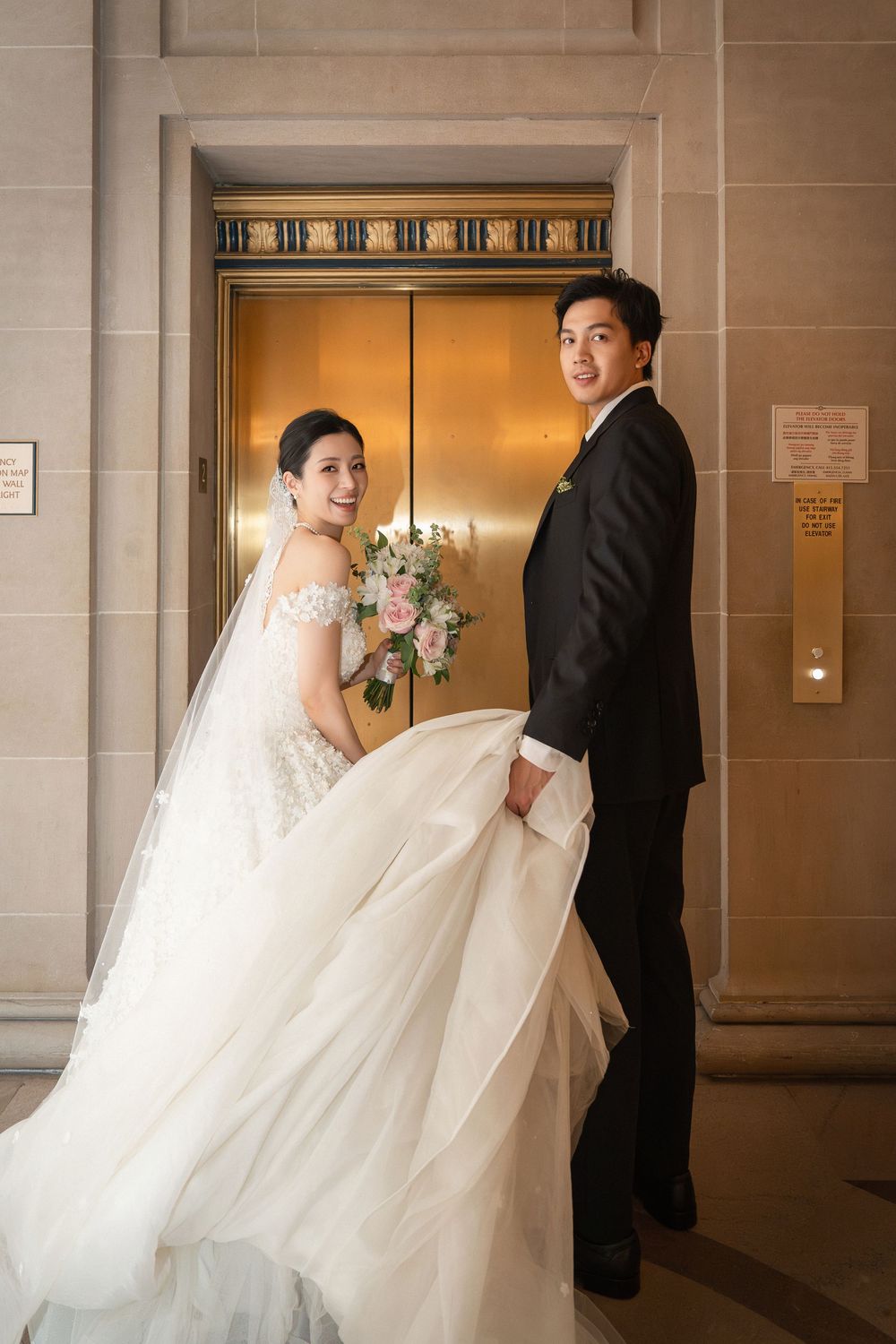 A wedding couple poses playfully in a series of shots along a modern hallway with stone walls and elevator.