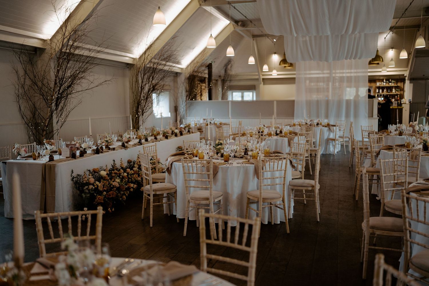 A black and white wedding reception scene inside a rustic venue with exposed brick walls and decorative lighting.