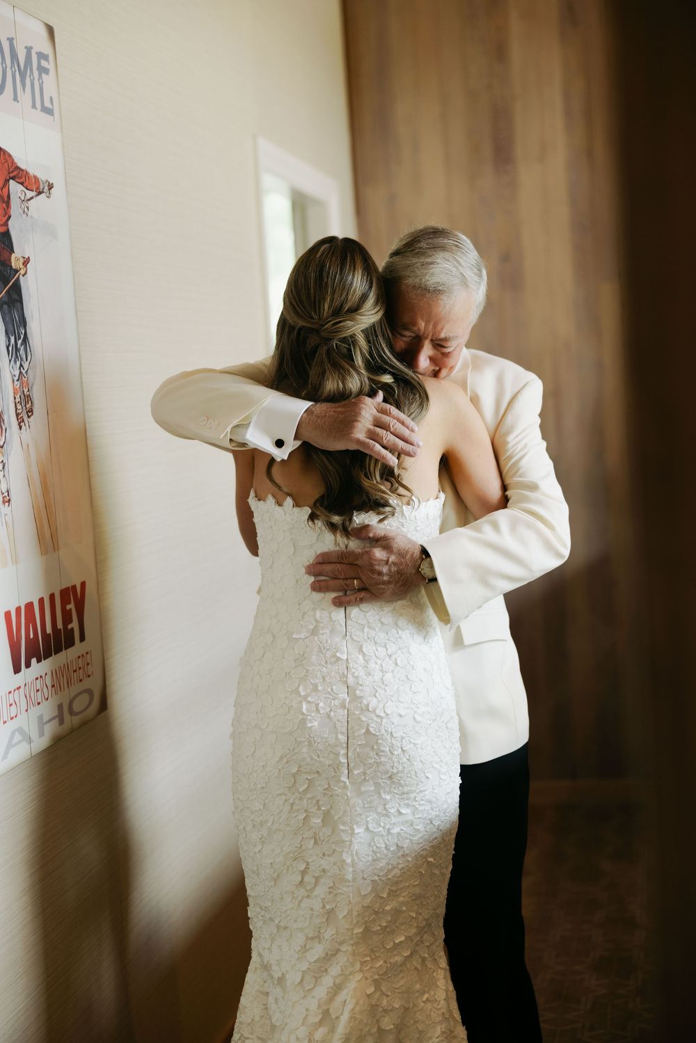 Emotional first look moment between bride in white dress and older relative at wedding venue.