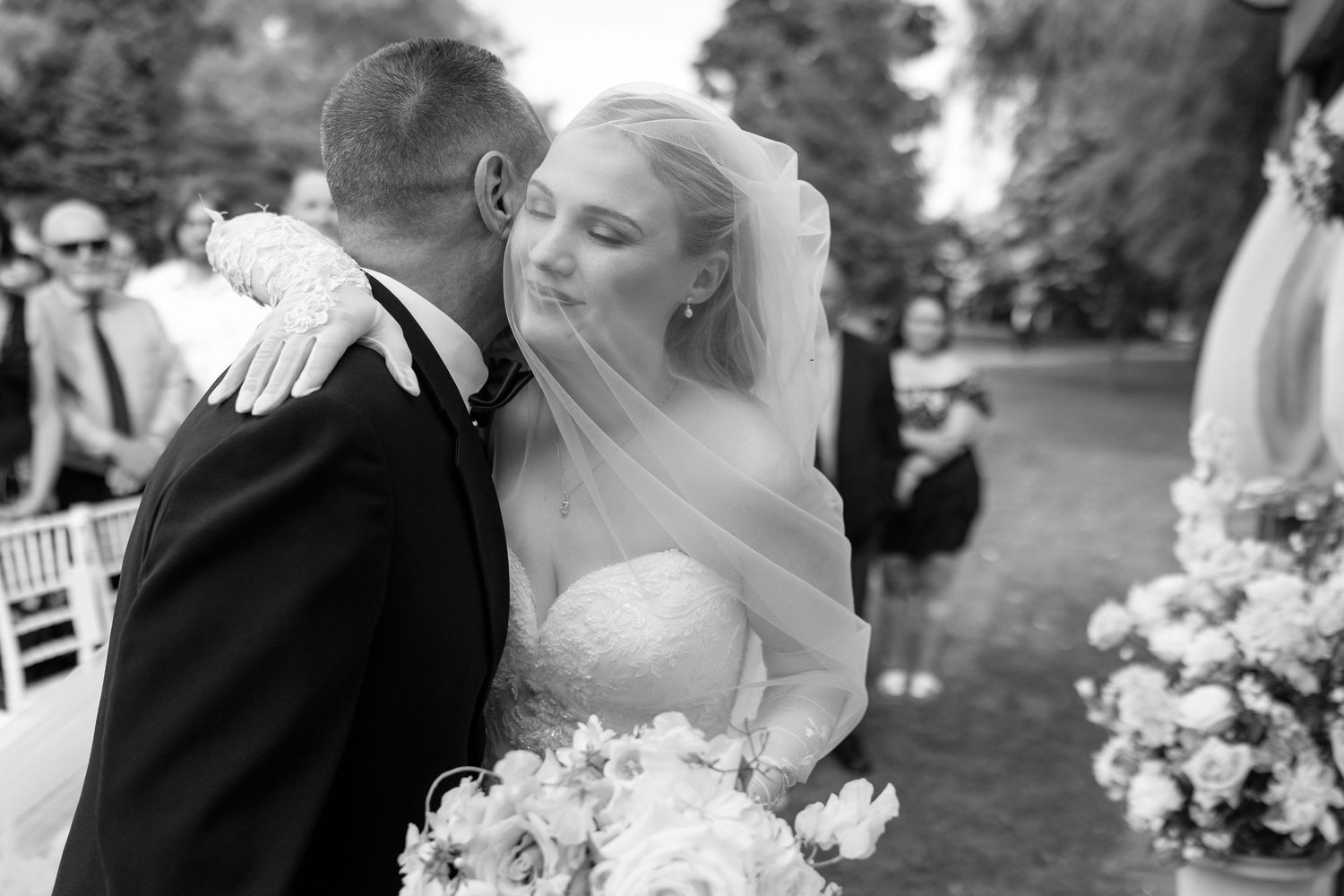Black and white wedding photo collage showing romantic moments between newlyweds during an outdoor garden ceremony.