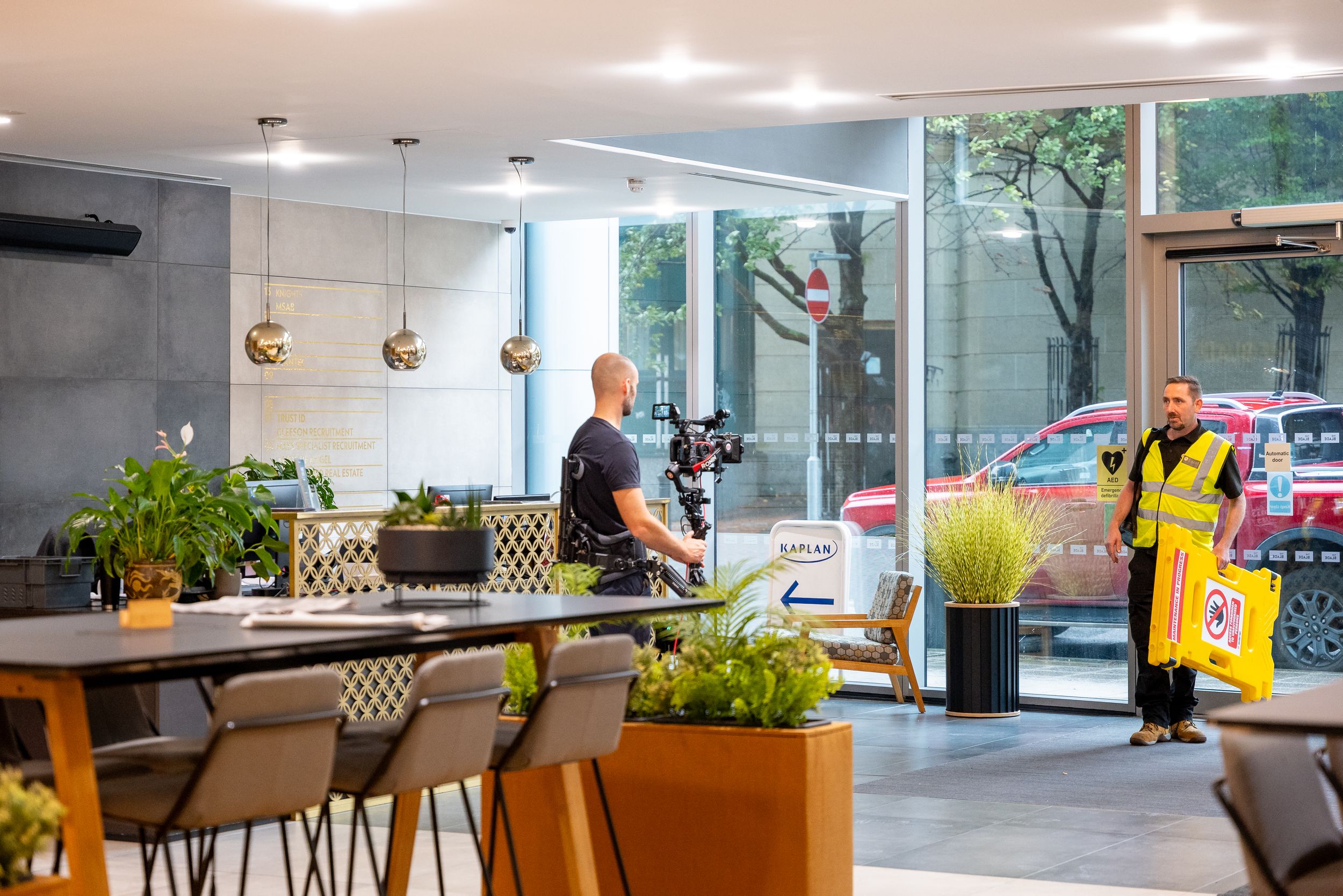 Modern office interior with stylish furniture and plants illuminated by natural light.