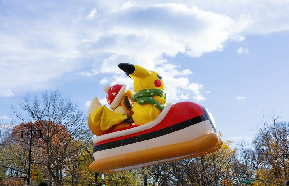 A series of colorful carnival rides and attractions against a cloudy sky at an amusement park.