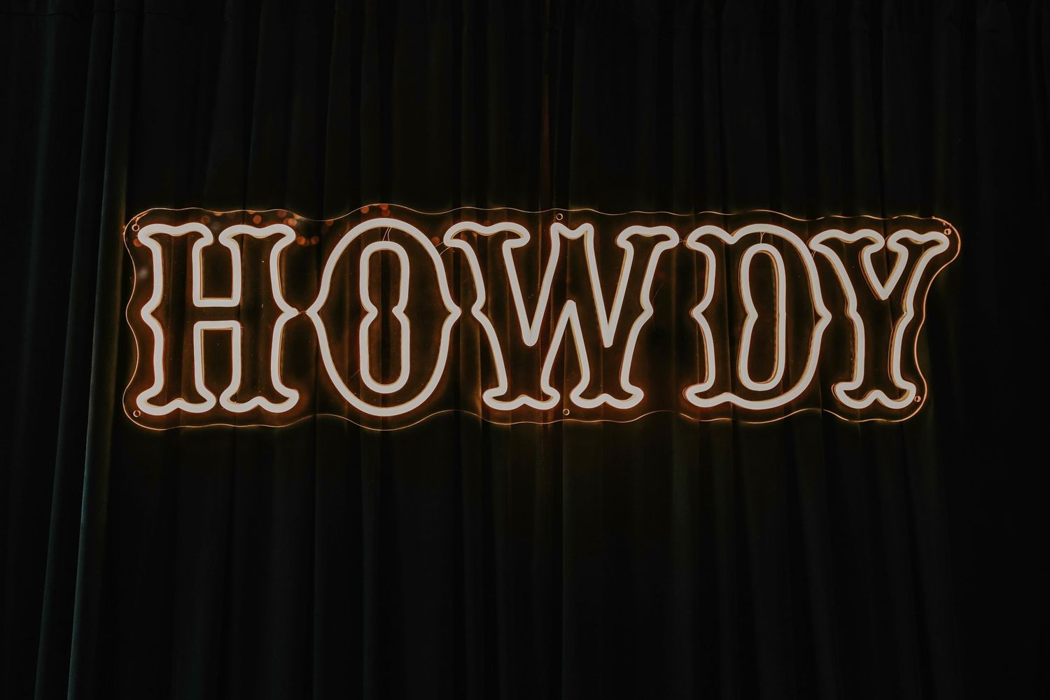 LED “Howdy” sign glowing at the wedding reception for a fun Texas-inspired décor moment.