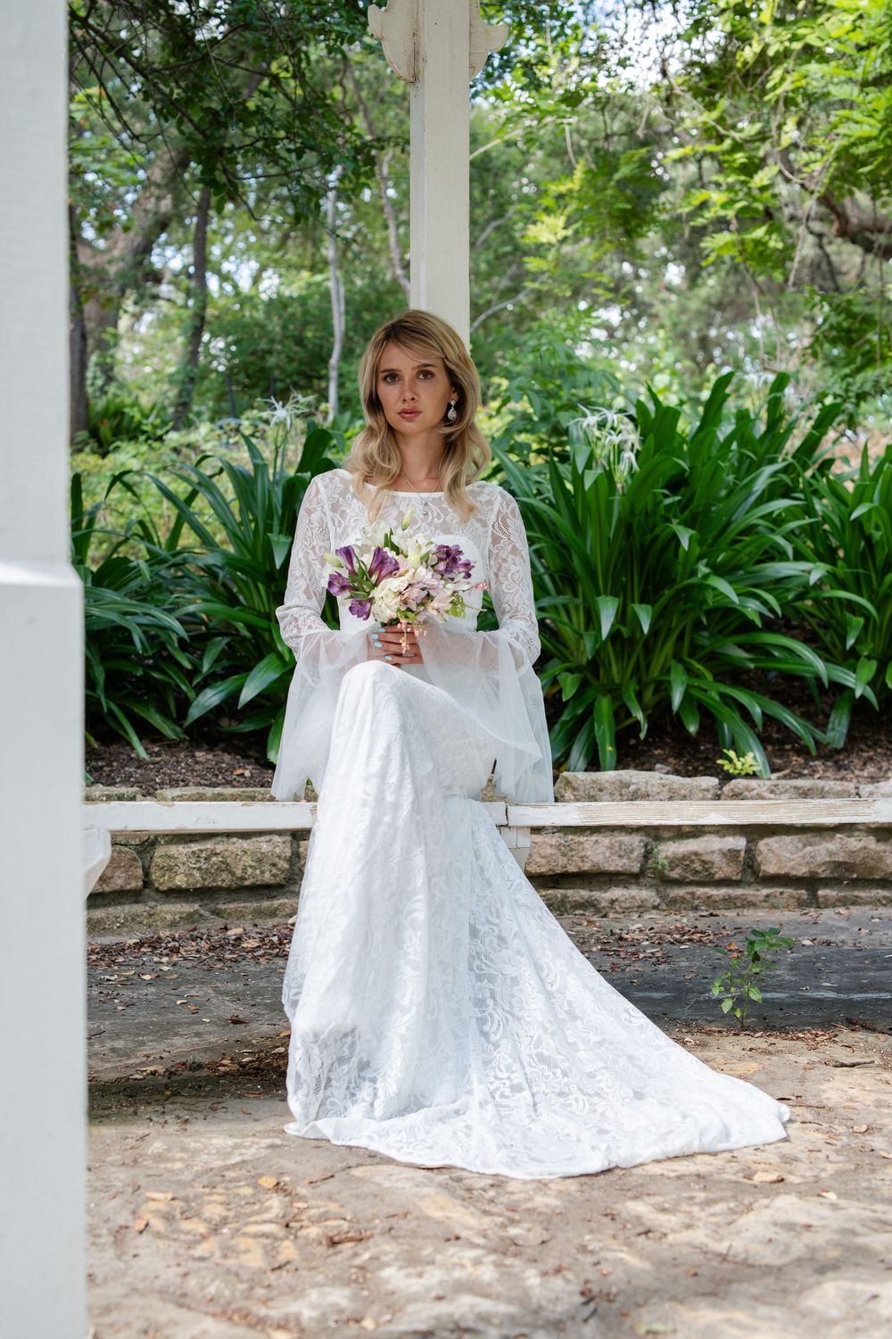 Multiple shots of a bride in a white lace dress posing in a garden pavilion setting.