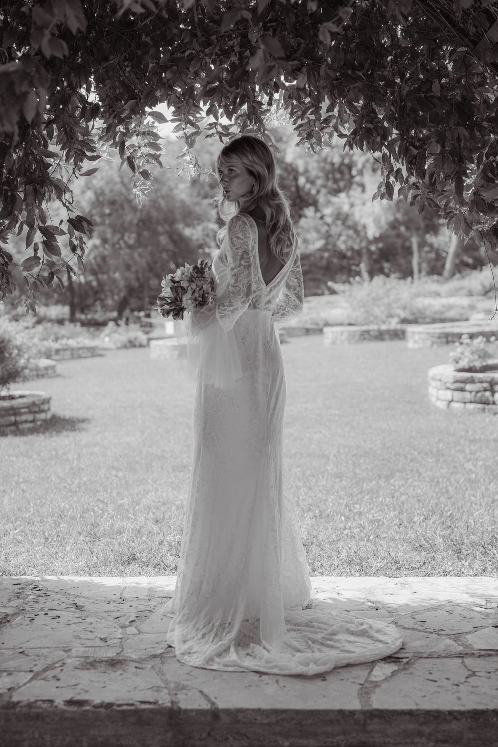Black and white series of a bride in a flowing dress under a covered outdoor space.